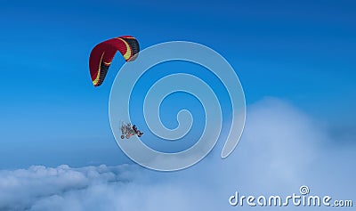 Red and black paramotor in the blue sky view. Stock Photo