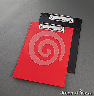 Red and black plastic clipboard on gray background. Stock Photo