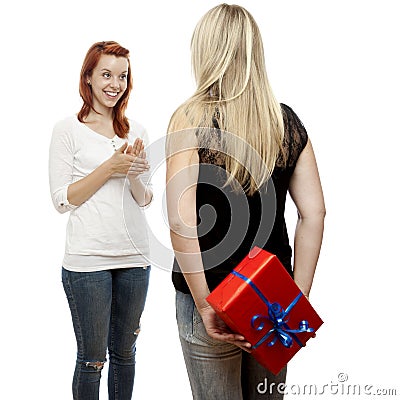 Red and blond haired girls with gift behind back Stock Photo