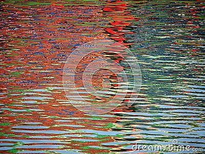 Red Blue Color pattern shimmers and reflects in ripples of water Stock Photo