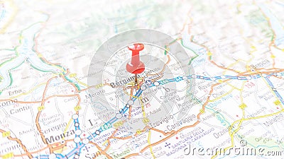 A red board pin stuck in Bergamo on a map of Italy Stock Photo