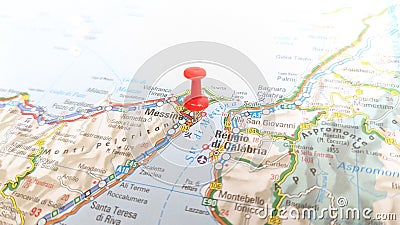 A red board pin stuck in Messina on a map of Sicily Italy Stock Photo
