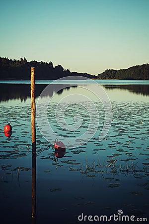 Red boat buoy in lake quiet evening Stock Photo