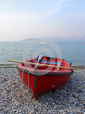 Red boat on rocky beach Stock Photo