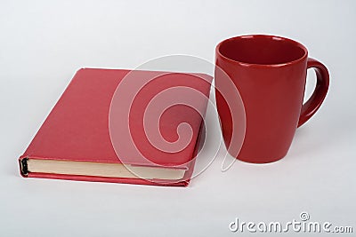 Red book and cup on a white table. Copy space for text. Stock Photo