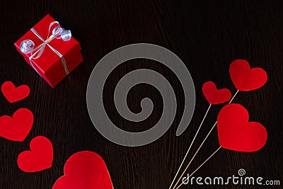 A red box tied with a white ribbon and red cardboard hearts, for Valentine's Day. Stock Photo