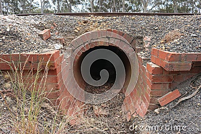 Red brick culvert drain under railroad tracks Stock Photo