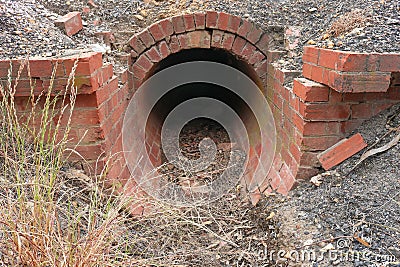 Red brick culvert drain under road Stock Photo