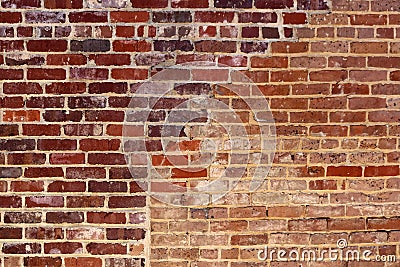Red brick grunge background with an area that used to be an opening filled in with different bricks Stock Photo