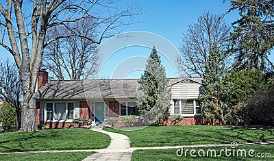 Brick Ranch Home Nestled in Trees with Curved Walk Stock Photo