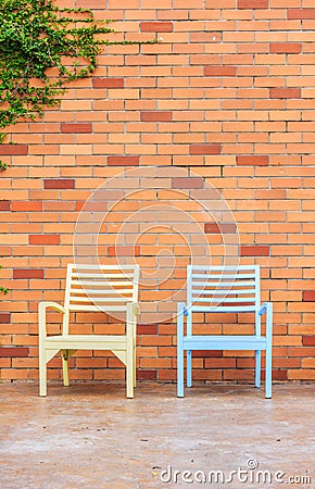 Red brick wall with chairs Stock Photo