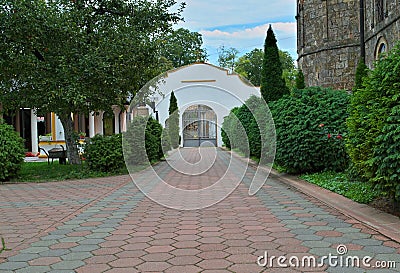 Red bricks sidewalk leading to gate in Serbian monastery Stock Photo