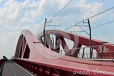 Red bridge over river IJssel in Zwolle for trains and with seperate cycle lane in the Netherlands. Editorial Stock Photo