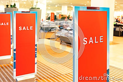 Red bright sale word banner on anti-thieft gate sensor at retail shopping mall entrance. Seasonal discount offer in Stock Photo