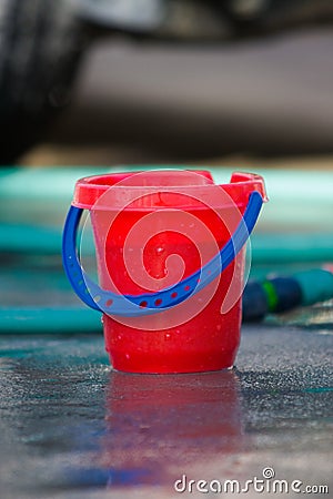 Red Bucket and Green Hose Stock Photo