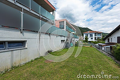 Red building exterior with large garden and glass parapet Stock Photo