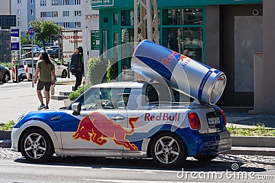 Red Bull Mini Cooper car with logo. mini cooper with a red bull branding decoration and a red bull can on the roof Editorial Stock Photo