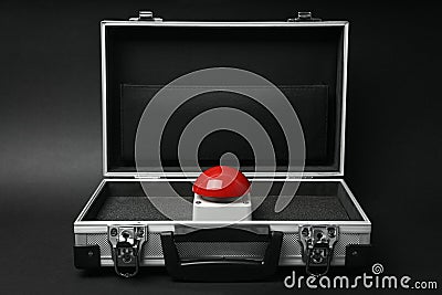 Red button of nuclear weapon in suitcase on black background. War concept Stock Photo