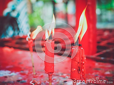 Red candle burning in old chinese church. Stock Photo