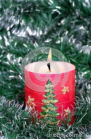 Red candle and green tinsel Stock Photo