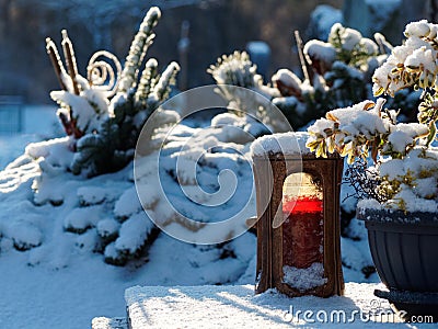 Red candle in snowy cemetery Stock Photo