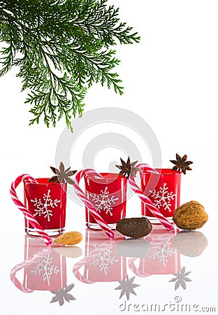 Red candles, candle holders with crystal snowflakes, sugar canes and anise stars, isolated on reflective white perspex background Stock Photo