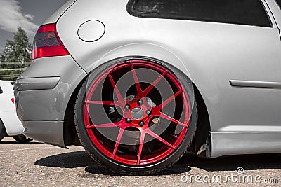Red candy colored light alloy wheels on silver hatchback Stock Photo