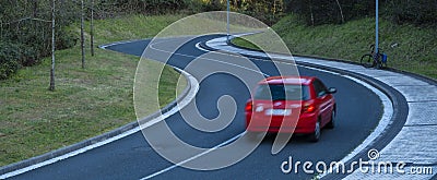 Red car driving fast on the curve of road Stock Photo