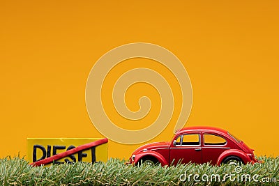 Chisinau 20.02.2020:A red car figurine aligned to the right on grass next to a sign which has the word diesel cut Stock Photo