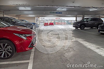 Red car parked in a busy parking station. Urban high car density and high cost of keeping automobile concept. Nobody. Light Stock Photo