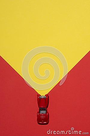 Red car is on rend and yellow abstract background with reflector on the road. Stock Photo