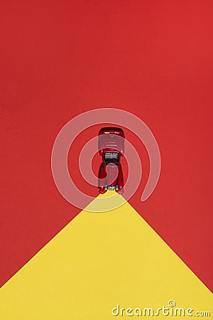 Red car is on rend and yellow abstract background with reflector on the road. Stock Photo