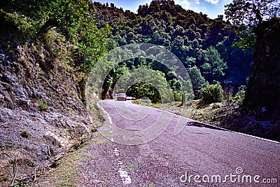 Red car speeding through a road in the mountains driving red car through the hills on vacation travelling in the himalayan mountai Stock Photo