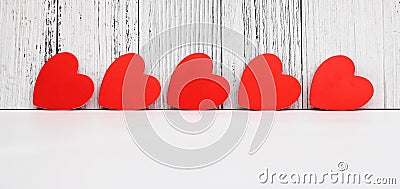 Red cardboard hearts are arranged in a row. Design and decoration for Valentine`s Day. concept of love Stock Photo