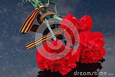 Red carnations with Saint George ribbon Stock Photo