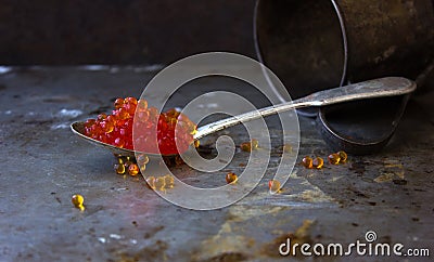Red caviar in an old silver spoon black moody background metal Stock Photo