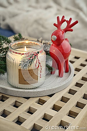 Red ceramic deer and candle in jar with fir tree branches Stock Photo