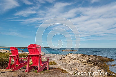 Red chairs facing Keji Seaside beach (South Shore, Nova Scotia, Stock Photo