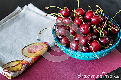 Red cherries in green ceramic bowl on dark background Stock Photo