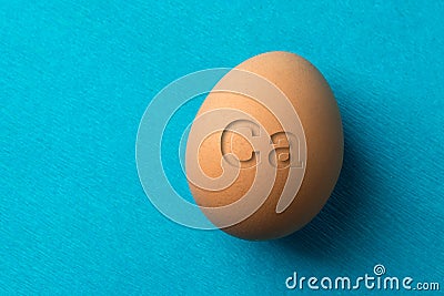 A red, chicken egg on a blue background, the eggs contain a lot of calcium for strengthening teeth and bones. Stock Photo