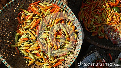 Red chili on a bamboo basket in a traditional market. Exposed to the morning sun. Stock Photo