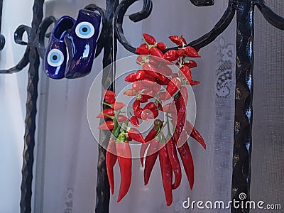 Red chilli peppers drying by window with blue charm shoes Stock Photo