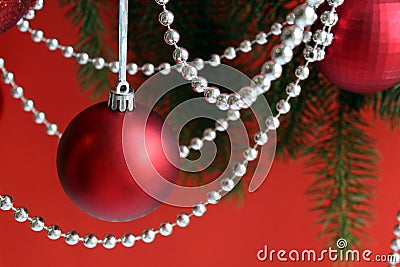 Red christmas balls with garland hang on a red background Stock Photo