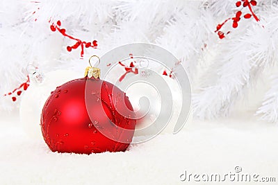 Red Christmas bauble with white balls in snow Stock Photo