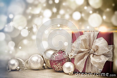 Red Christmas gift box and baubles on background of defocused golden lights. Stock Photo