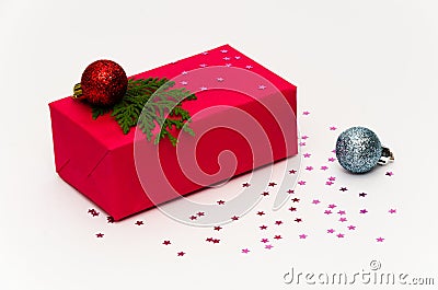 Red Christmas gift box decorated with fir tree branch, Christmas balls on a white background adorned with pink stars Stock Photo