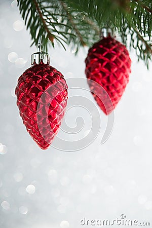 Red christmas ornaments cones on the xmas tree on glitter bokeh background. Stock Photo