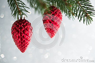 Red christmas ornaments cones on the xmas tree on glitter bokeh background. Merry christmas card. Stock Photo