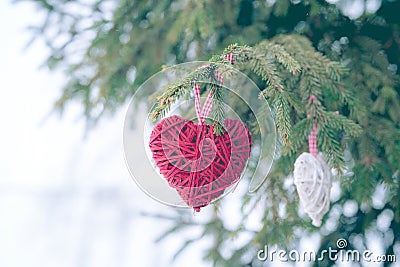 Red Christmas ornaments, heart, on a Christmas tree Merry Christmas greeting card. Winter holiday theme. Stock Photo