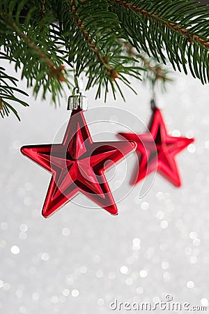 Red christmas stars on the xmas tree on glitter bokeh background. Stock Photo